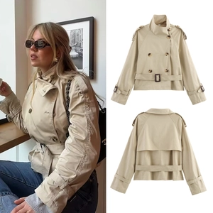 Detail showing khaki double-breasted short trench coat with belt and epaulette accents