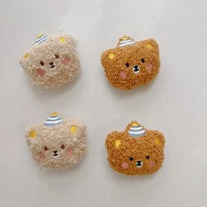 Detailed view of four plush teddy bear patches with party hats for DIY crafts and accessories