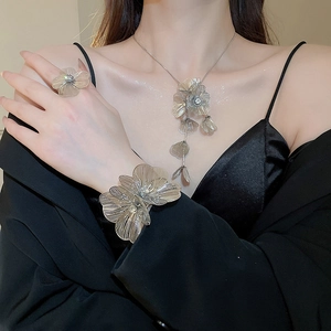 Detail view of model wearing a luxury floral rhinestone tassel necklace jewelry set