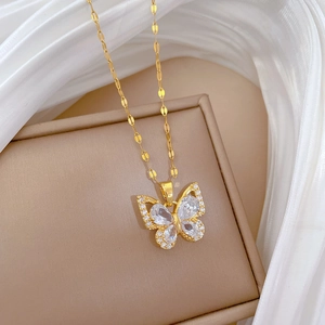 Close-up of golden butterfly necklace with pear-cut zircons on premium silk