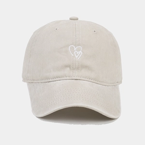 Detailed view of the double heart embroidery on the washed beige cotton baseball cap