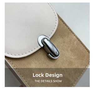 Close-up of the silver metal lock on a stylish two-tone leather and suede handbag