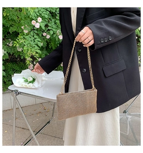 Detailed shot of a champagne gold rhinestone envelope bag with golden chain straps