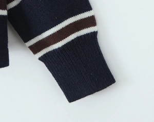 Close-up of ribbed cuffs on a navy blue striped polo shirt with knit texture