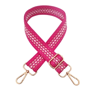 Detail of adjustable woven handbag strap in rose pink with luxury gold metal clasps