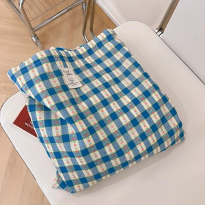 Detail of blue and yellow checkered cotton tote bag with small red floral patterns