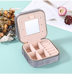 Detail view of the gray velvet jewelry box featuring an interior mirror and earring panel