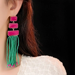Vintage long tassel earrings with green beads and pink resin modules on female model
