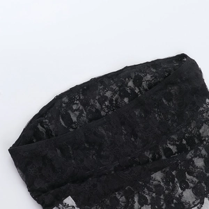 Dettaglio ravvicinato del pizzo nero con motivi floreali e cuciture di alta qualità