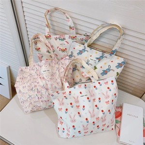 Detail of four colorful cotton canvas tote bags featuring cute rabbit and floral patterns