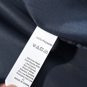 Detail view of the 100% polyester care label and washing instructions for plaid coat