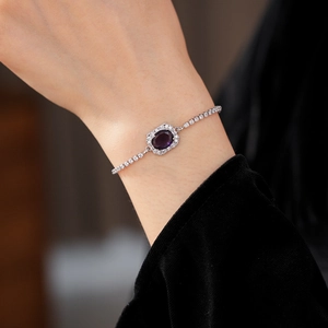 Close-up of a silver-tone bracelet featuring a deep purple oval stone worn on a wrist