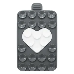 Close-up of heart-shaped silicone suction cup phone holder with matte grey finish