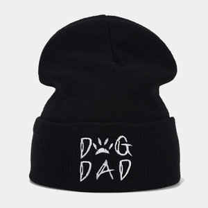 Detailaufnahme einer schwarzen Strickmütze mit weißem DOG DAD Stick und Pfotenmotiv