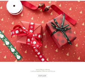 Detail of red and green Christmas ribbons with Santa and gold lettering on gift box