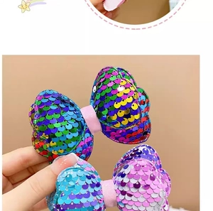 Detail of glitter bow hair clips with colorful sequins and soft pink felt backing material