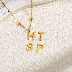 Elegant gold stainless steel letter necklace with H, T, S, P charms and beaded chain