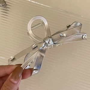 Dettaglio del fermaglio per capelli a fiocco in metallo argento con strass scintillanti