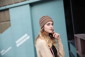 Outdoor close-up of brown ribbed knit beanie with stylish folded cuff design
