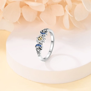 Silver celestial ring with sun, moon, and star motifs featuring colorful gemstones