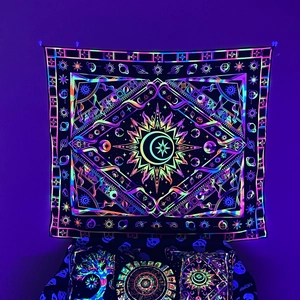 Glow-in-the-dark bohemian tapestry with celestial sun and moon patterns in neon light