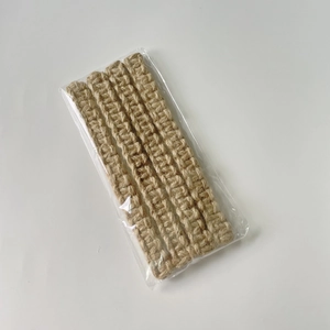 Detail of hand-woven beige cotton rope curtain tieback in transparent retail packaging