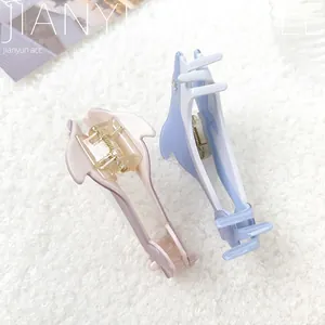 Elegant dolphin hair claws in blue and pink acetate with rhinestones on plush background