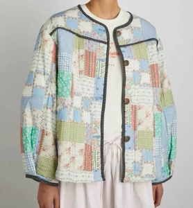 Detail of multi-pattern patchwork quilted jacket with black polka dot piping and round neck