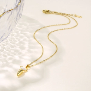 Collier en acier inoxydable doré avec pendentif carotte en zircon sur fond uni