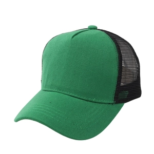 Detail of green cotton crown and black breathable mesh back on the adjustable trucker cap