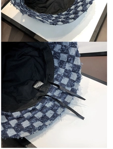 Detail of adjustable inner drawstring and washing label of checkered denim bucket hat