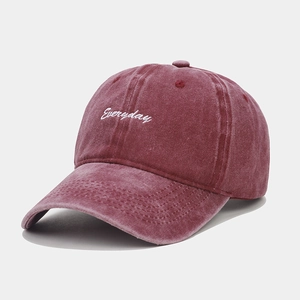 Close-up of white 'Everyday' embroidery on a washed burgundy vintage cotton baseball cap