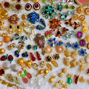 Collezione di orecchini e spille vintage dorati con dettagli in smalto e cristalli