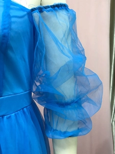 Nahaufnahme eines hellblauen Abendkleids mit bauschigen Organza-Laternenärmeln und Satin-Mieder