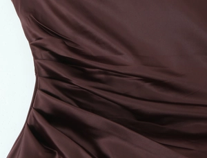 Detailed close-up of dark brown satin evening dress showing gathered pleats texture