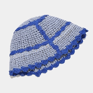 Close-up of light blue straw bucket hat with dark blue plaid crochet and scalloped edge