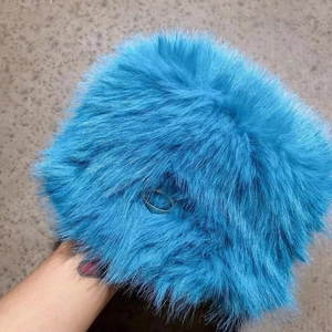 Detail view of electric blue faux fur handbag featuring a polished silver metal ring handle