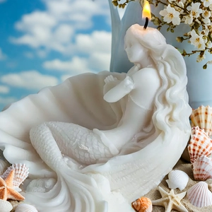 Bougie sirène coquillage blanche sur sable avec décor d'étoiles de mer sur la plage