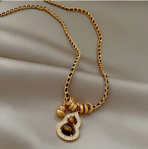 Macro shot of 18K gold plated gourd pendant with tiger eye stones and zircon inlay