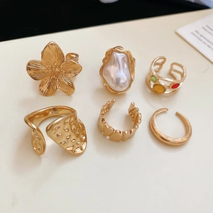 Detail of a 6-piece golden jewelry set featuring starfish and floral geometric designs