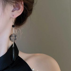 Detailed view of Chinese ink style fan earring with calligraphy bead and black tassel