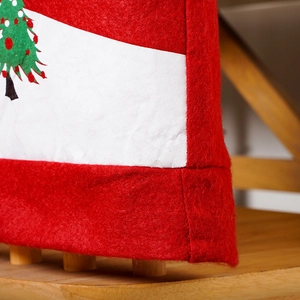 Detail of red non-woven Christmas chair cover with white border and green tree pattern