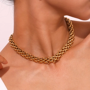 Detail of chunky triple-layered gold woven chain necklace on model's neck for hip-hop style