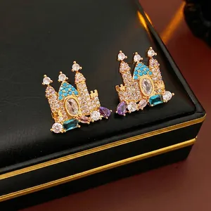 Luxurious gold-plated castle earrings set with colorful gemstones on a black jewelry box