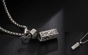 Dettaglio della collana diffusore vintage con medaglione magnetico e motivo inciso in rilievo