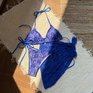 Detail of blue lace floral bikini top with matching sheer mesh cover-up skirt