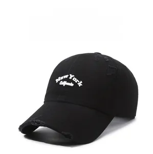 Detail of black distressed baseball cap with white New York California embroidery