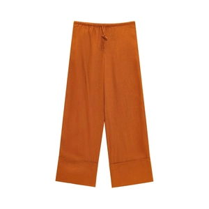 Dettaglio della trama in lino dei pantaloni larghi rosso ruggine con coulisse