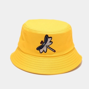 Detailed close-up of yellow cotton bucket hat featuring intricate dragonfly embroidery