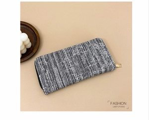 Close-up of black and white woven tweed pattern on a long lady's fashion purse